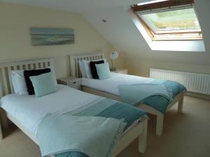 two beds in a room with a window at Chesil View House in Portland