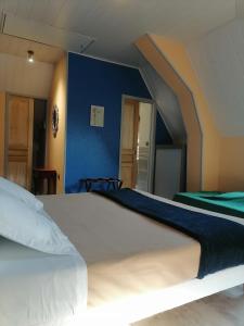 un grande letto in una camera da letto con parete blu di LES 4 VENTS a Saint-Berain-sur-Dheune Altre 4 foto