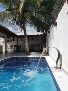 a swimming pool with a water fountain in front of a house at Casa do Tio Eri - Geribá - 100 metros da Praia in Búzios