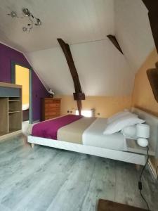una camera da letto con un letto grande in una mansarda di LES 4 VENTS a Saint-Berain-sur-Dheune