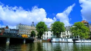 un puente sobre un río frente a los edificios en Rembrandt Square Boat en Ámsterdam