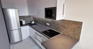 a kitchen with a sink and a refrigerator at Sky 17 Lux apartman in Zagreb