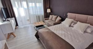 a bedroom with a large bed and a couch at Sky 17 Lux apartman in Zagreb