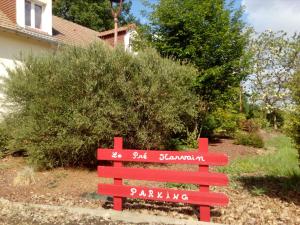 a red bench with writing on it in front of a house at Le Pre Karvain in Couddes