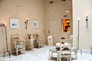 a salon with four chairs and a table with flowers at Hostal Callejon del Agua in Seville