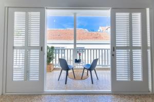 a view of a table and chairs through a sliding glass door at Boutique Homes Willemstad City Centre in Willemstad