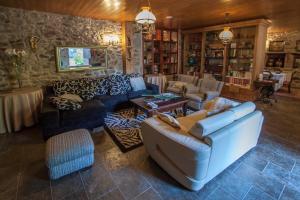 a large living room with a couch and chairs at Casas Rurales A Peregrina in Codeseda