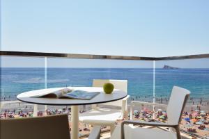 a table and chairs with a view of a beach at Don Cesar Boutique Apartments in Benidorm