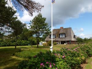 Una casa vieja con una bandera encima en LH Bremer Strasse, Hausteil 2, en Wenningstedt