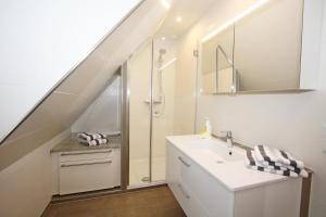 a bathroom with a sink and a shower at C-Haus Cordula, App 41 in Wenningstedt +8 photos