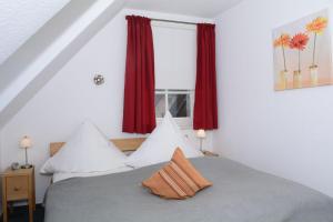 ヴェニングシュテットにあるLH Heidegrund, App 3のベッドルーム1室(ベッド2台付)、赤いカーテン付きの窓が備わります。