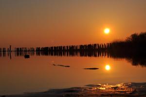 una puesta de sol sobre un lago con la puesta de sol en Pension Lemke, en Polchow