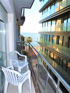 balcón con 2 sillas blancas y vistas al océano en Apartaments Tropic, en Lloret de Mar