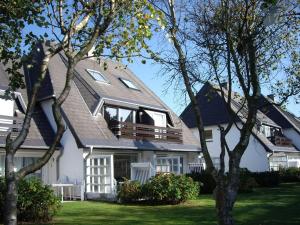 a house with a gambrel roof with a balcony at C-Haus Cosima, App 80 in Wenningstedt
