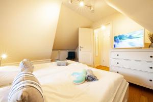 a bedroom with two beds and a tv on the wall at SyltStern Haus Hasenkuhle in Wenningstedt
