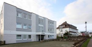 a large white building next to a building at Strandlust im Haus Caecilia in Wenningstedt