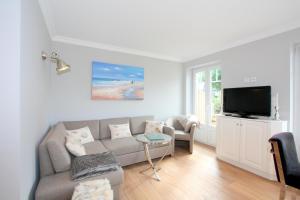 a living room with a couch and a tv at Düne 20 in Westerland (Sylt)