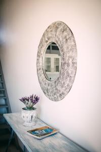 un espejo en una pared junto a una mesa en Oppikoppie Langebaan, en Langebaan