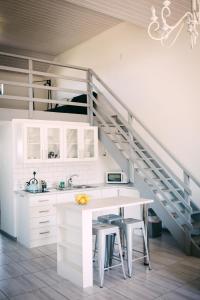 een keuken met witte kasten en een trap bij Oppikoppie Langebaan in Langebaan