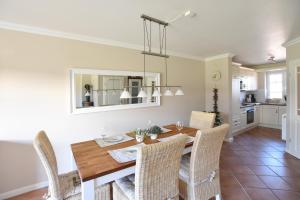 Un comedor con mesa y sillas de madera. en Ferienhaus Gartenweg, en Tinnum