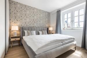 een slaapkamer met een groot wit bed en een muur bij Strandgut Wohnung 4 in Wenningstedt