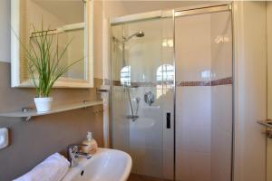 un baño con ducha y lavabo en Ferienhaus Gartenweg, en Tinnum 18 fotos más
