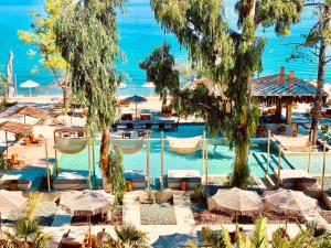 a view of a pool with umbrellas and the ocean at MAKO Sea & Suites in Pefkohori