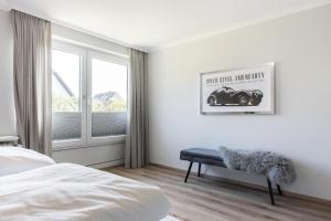 ヴェニングシュテットにあるHaus Weissenburg, Whg EG Ostのベッドと窓のある白い寝室