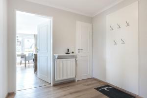 ヴェニングシュテットにあるHaus Weissenburg, Whg EG Ostの白いドアとテーブルが備わる白い部屋 +11枚の写真