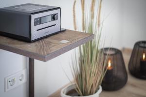 ヴェニングシュテットにあるHaus Weissenburg, Whg EG Ostの植物の横のテーブルに座る電子レンジ