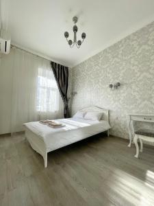 a bedroom with a white bed and a table at Cozy apartment on Greek street 15 in Odesa