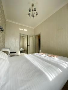 a large white bed in a bedroom with a chandelier at Cozy apartment on Greek street 15 in Odesa