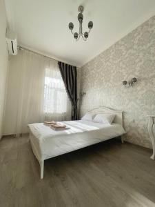 a white bed in a room with a window at Cozy apartment on Greek street 15 in Odesa