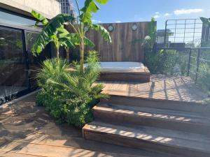 ブエノスアイレスにあるNuevo Loft en Palermo Hollywoodの木製デッキのホットタブ付きの庭園