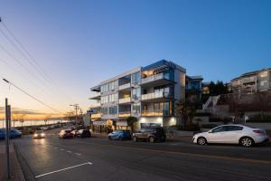 a city street with cars parked in front of a building at Ocean Promenade Hotel in White Rock