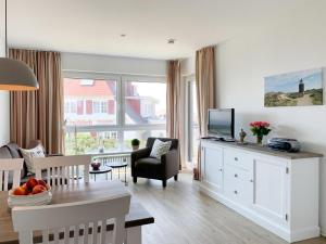 sala de estar con TV y comedor en Schloss am Meer, App 9, en Wenningstedt