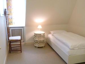 una camera con letto, sedia e lampada di LH Bremer Strasse, Hausteil 1 a Wenningstedt