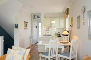 a kitchen and dining room with a table and chairs at LH Westerhörn, App 1 in Wenningstedt +8 photos