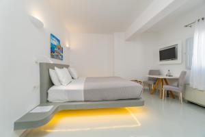 a bedroom with a bed and a desk and a tv at Central Fira Suites in Fira