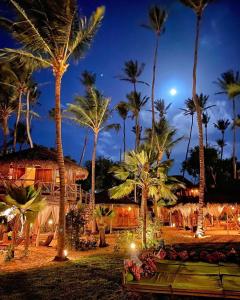 een resort met palmbomen en 's nachts verlichting bij Vila Kalango in Jericoacoara