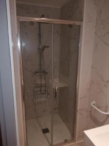 a shower with a glass door in a bathroom at gite repos et tranquillité P in Cayeux-sur-Mer