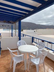 d'une table et de chaises blanches sur un balcon. dans l'établissement CASA LOS JUANES, à Caleta de Sebo