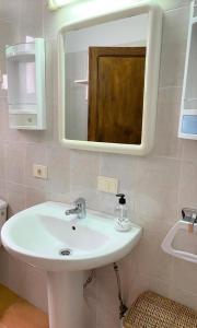 y baño con lavabo blanco y espejo. en CASA LOS JUANES, en Caleta de Sebo