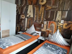 2 camas en una habitación con una pared con letras en Ferienwohnungen "Zur Schamper Mühle" Gotthun, en Gotthun