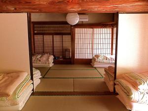 una habitación con 2 camas y una habitación con esterillas en Kominka Sharehouse Hooju - Vacation STAY 10518 en Miyazaki