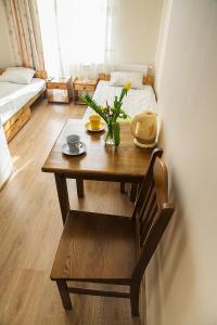 Habitación con mesa de madera, silla y cama. en Pokoje Stare Miasto, en Cracovia