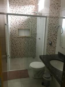 uma casa de banho com um chuveiro, um WC e um lavatório. em Hotel Hollywood em Lucas do Rio Verde