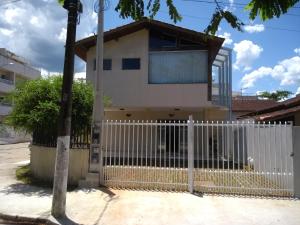 a white fence in front of a house at Boa Vida Ubatuba in Ubatuba