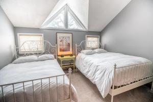 a attic bedroom with two beds and a window at Blue Mountain Slopeside Chalet in Chateau Ridge in Blue Mountains