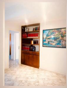una stanza con una libreria e un dipinto sul muro di Via Solaro, appartamento in pieno centro a Formia